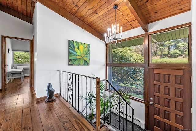 corridor featuring hardwood / wood-style floors, baseboards, wood ceiling, a chandelier, and an upstairs landing