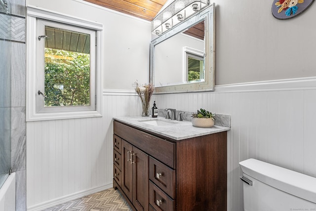 full bath featuring plenty of natural light, a wainscoted wall, and vanity
