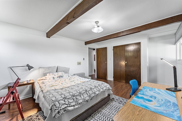 bedroom with wood finished floors and beam ceiling