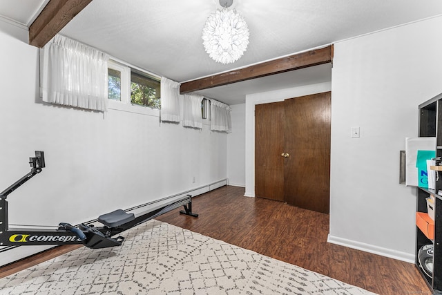 exercise area with baseboards, a baseboard radiator, wood finished floors, and a chandelier