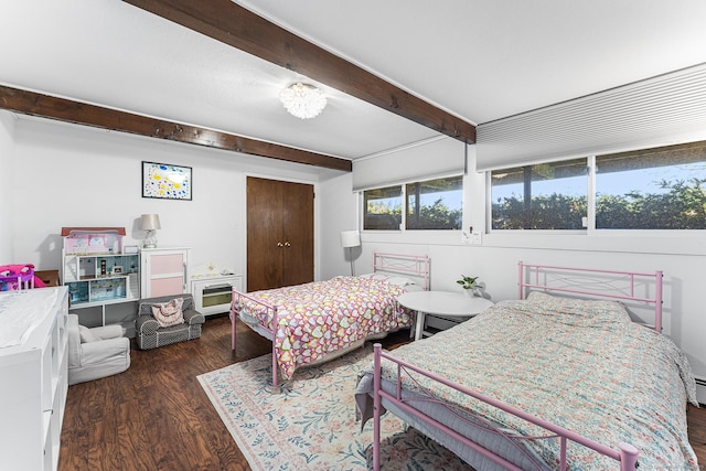 bedroom with wood finished floors, beam ceiling, and a closet