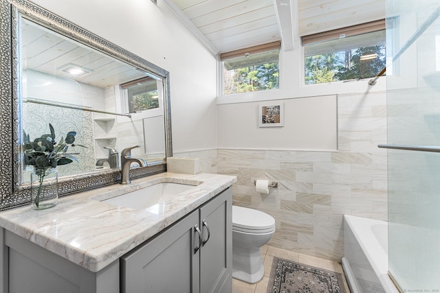 full bathroom featuring vanity, toilet, tile patterned floors, a washtub, and tile walls