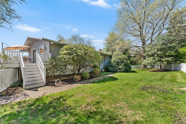 view of yard with a fenced backyard, stairway, and a deck