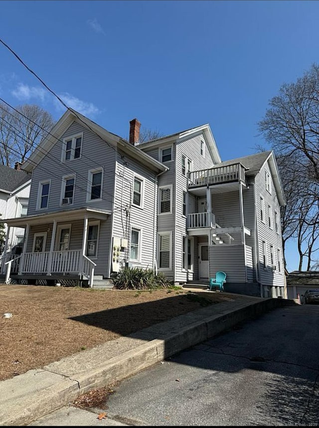 view of front of home featuring a porch and a chimney