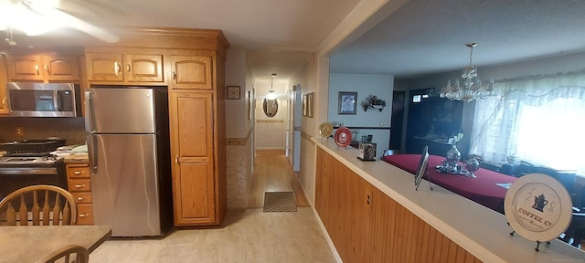 297 Whittemore Rd, Middlebury, CT 06762 - kitchen featuring appliances with stainless steel finishes, light countertops, a chandelier, and decorative light fixtures