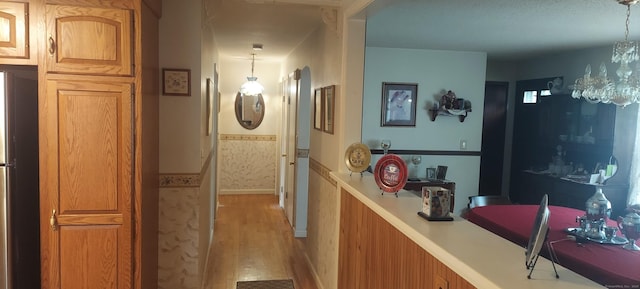 297 Whittemore Rd, Middlebury, CT 06762 - corridor featuring light wood-style floors, a chandelier, wainscoting, and baseboards