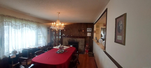297 Whittemore Rd, Middlebury, CT 06762 - dining area with a chandelier, a stone fireplace, wood walls, and wood finished floors