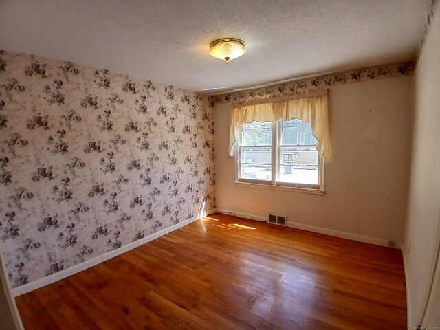 297 Whittemore Rd, Middlebury, CT 06762 - empty room featuring wood finished floors, baseboards, a textured ceiling, and wallpapered walls