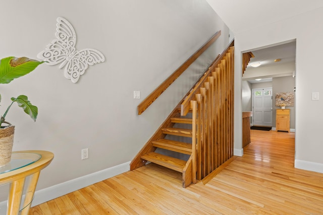 staircase with baseboards and wood finished floors