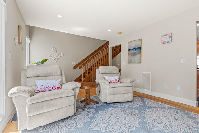 living area with visible vents, wood finished floors, stairway, baseboards, and recessed lighting