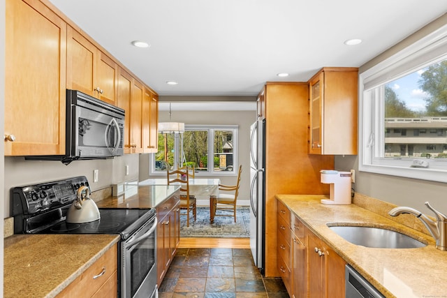 kitchen with stone tile floors, stainless steel appliances, recessed lighting, and a sink