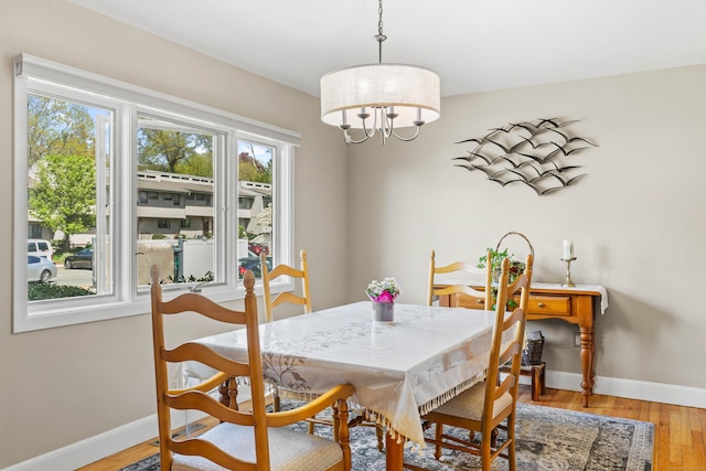 dining area with baseboards, plenty of natural light, and light wood finished floors