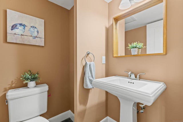 half bathroom featuring a sink and toilet