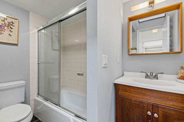 full bath with vanity, toilet, and shower / bath combination with glass door