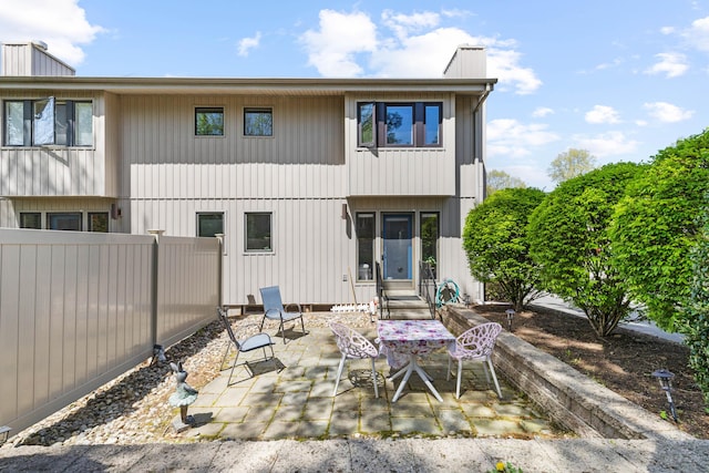 rear view of house featuring fence and a patio area
