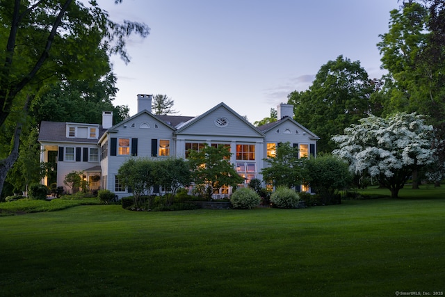 view of front facade featuring a chimney and a front yard