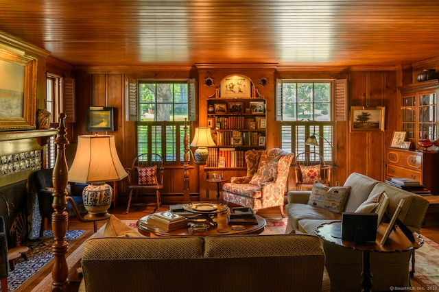 sitting room featuring crown molding, wooden walls, and wood finished floors