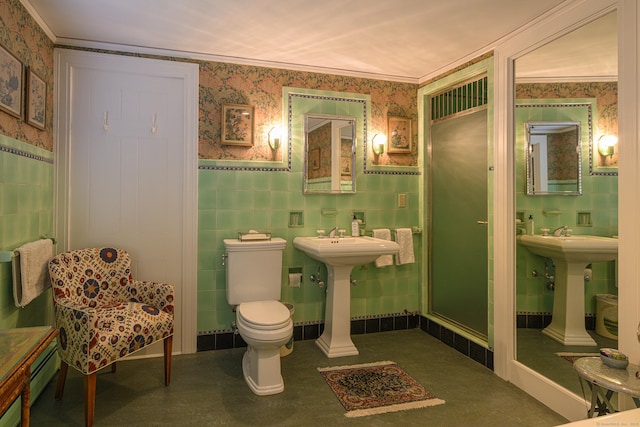 full bathroom featuring wallpapered walls, toilet, tile walls, and wainscoting