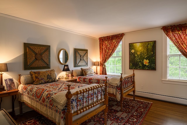 bedroom featuring ornamental molding, a baseboard radiator, and wood finished floors