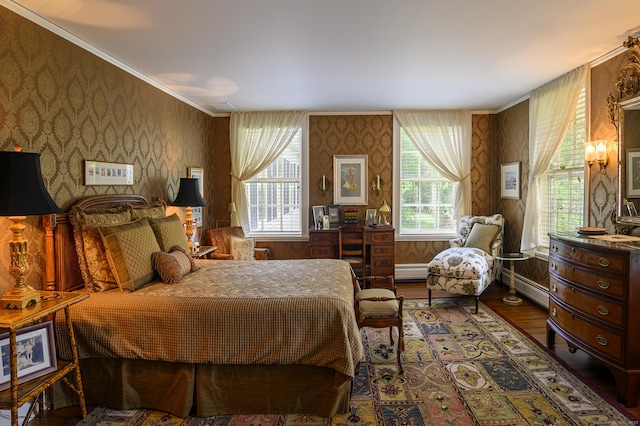 bedroom with a baseboard heating unit, wallpapered walls, and wood finished floors