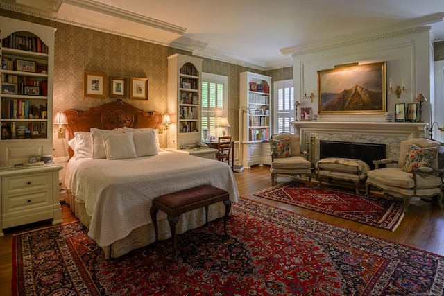 bedroom with a fireplace, crown molding, wallpapered walls, and wood finished floors
