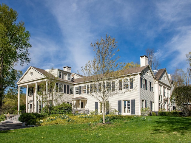 rear view of house with a yard and a chimney