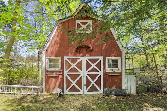 view of barn featuring fence