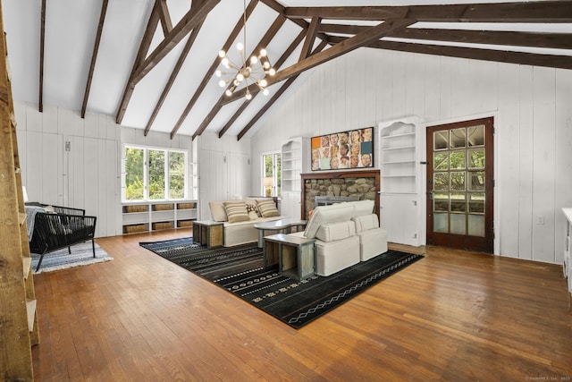 living room featuring a fireplace, beamed ceiling, wood-type flooring, and wood walls