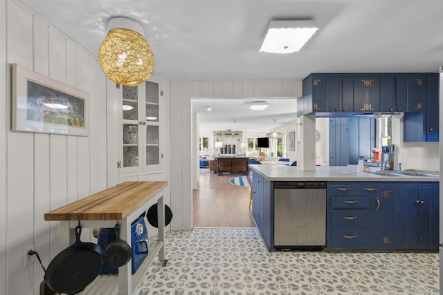 kitchen featuring light floors, dishwasher, a wealth of natural light, and blue cabinetry