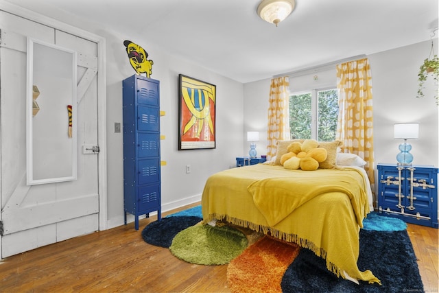 bedroom with baseboards and wood finished floors