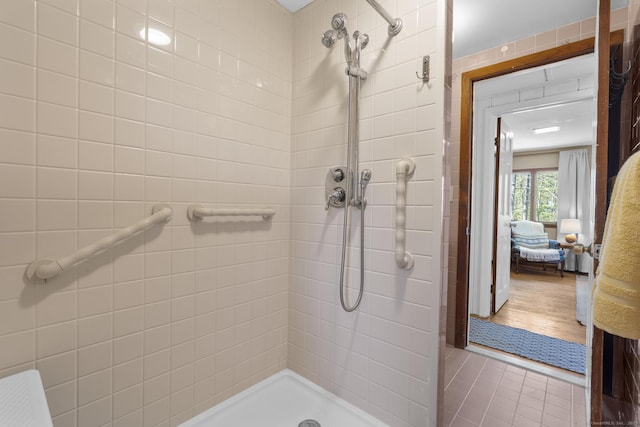 bathroom featuring tile patterned flooring and a tile shower