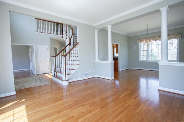 unfurnished living room with ornate columns, wood finished floors, and visible vents