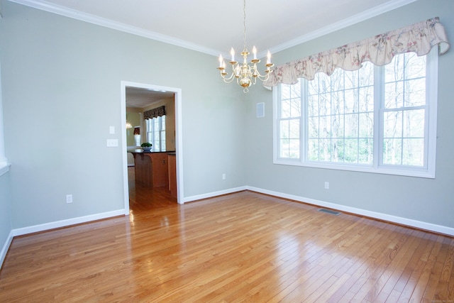 unfurnished room with visible vents, baseboards, light wood finished floors, a chandelier, and ornamental molding