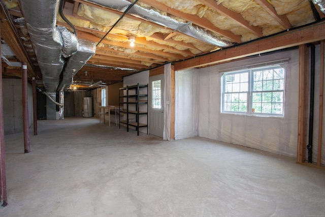 basement featuring plenty of natural light and water heater