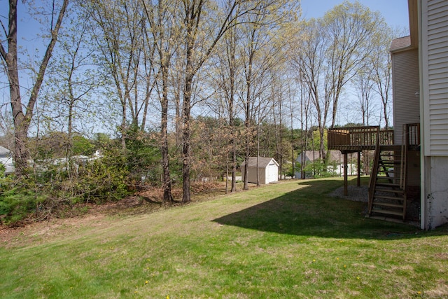 view of yard featuring a storage unit, an outbuilding, a deck, and stairway