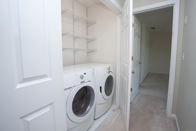 laundry room with baseboards, light carpet, and washing machine and clothes dryer