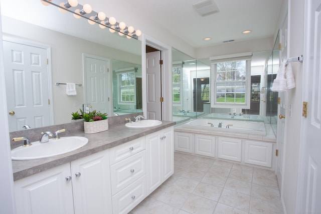 full bathroom with double vanity, recessed lighting, a sink, and a garden tub