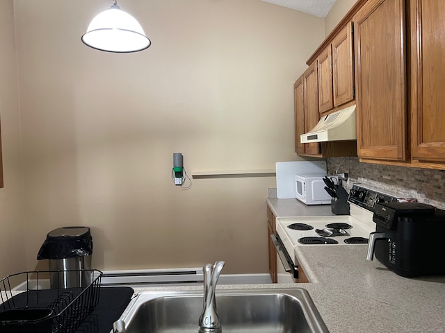 kitchen featuring under cabinet range hood, a sink, brown cabinetry, and range with electric stovetop