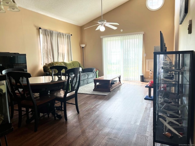 dining room featuring a textured ceiling, a ceiling fan, vaulted ceiling, and wood finished floors