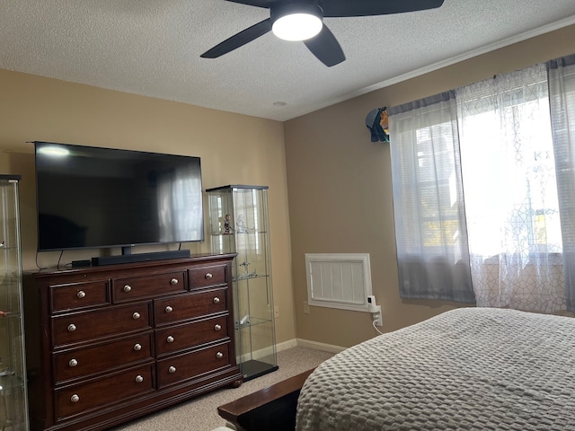 bedroom with baseboards, a ceiling fan, a textured ceiling, and light carpet