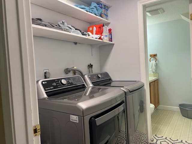 laundry area featuring independent washer and dryer, laundry area, and baseboards