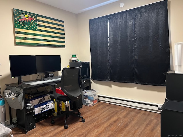 office space featuring radiator heating unit, baseboard heating, and wood finished floors