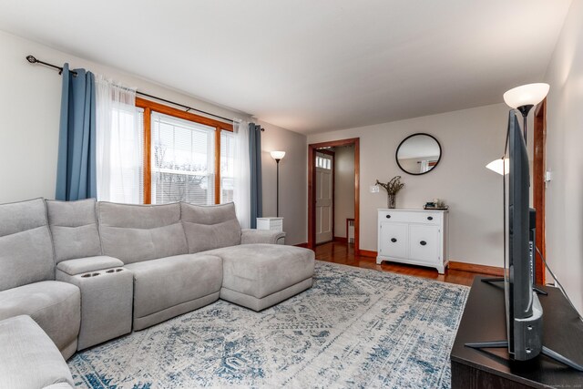 living area with baseboards and wood finished floors