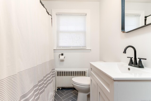 bathroom featuring vanity, toilet, tile patterned floors, radiator heating unit, and a shower with curtain