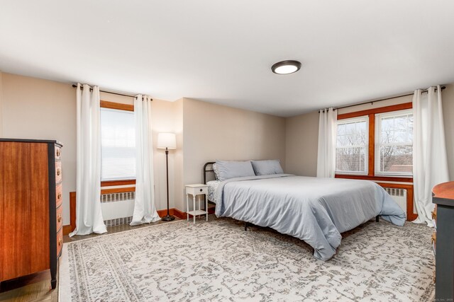 bedroom with radiator heating unit and wood finished floors