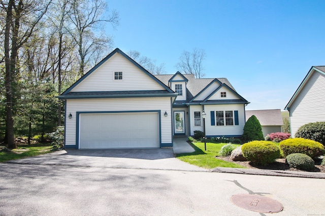 traditional-style house featuring an attached garage and aphalt driveway