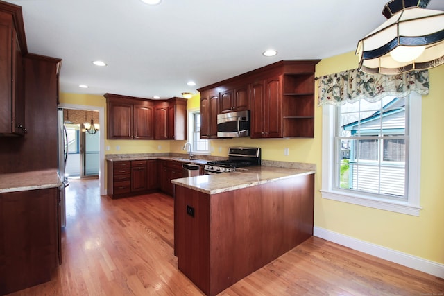 5 Marjories Way Unit 5, East Lyme, CT 06357 - kitchen featuring appliances with stainless steel finishes, a peninsula, open shelves, light wood finished floors, and a sink