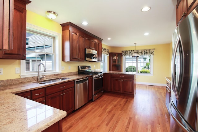 5 Marjories Way Unit 5, East Lyme, CT 06357 - kitchen with stainless steel appliances, a sink, a peninsula, light wood-style flooring, and pendant lighting