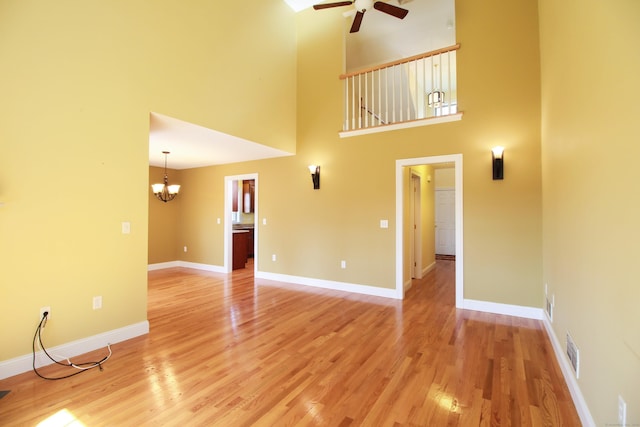 5 Marjories Way Unit 5, East Lyme, CT 06357 - unfurnished living room featuring ceiling fan, a chandelier, light wood-type flooring, a high ceiling, and baseboards