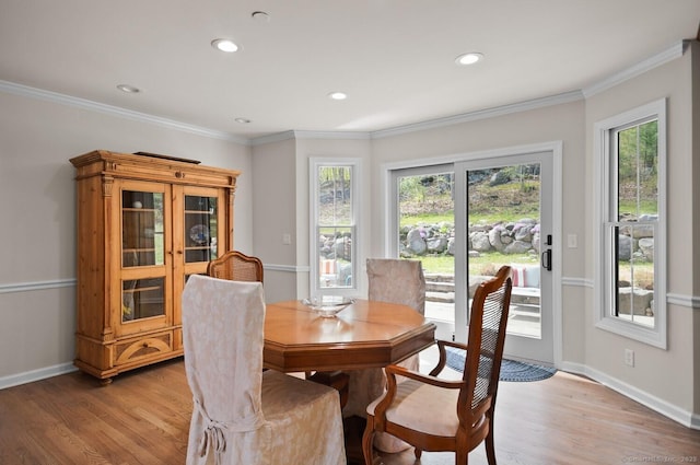 dining area with crown molding, baseboards, plenty of natural light, and light wood-type flooring